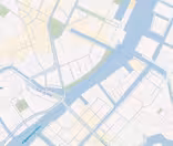 Et digitalt kort, der viser en flod, der løber gennem en by, med forskellige broer og gader mærket på dansk. Området omfatter bygninger, parker og vandveje, der illustrerer en del af en by med detaljerede planlægningslinjer.
